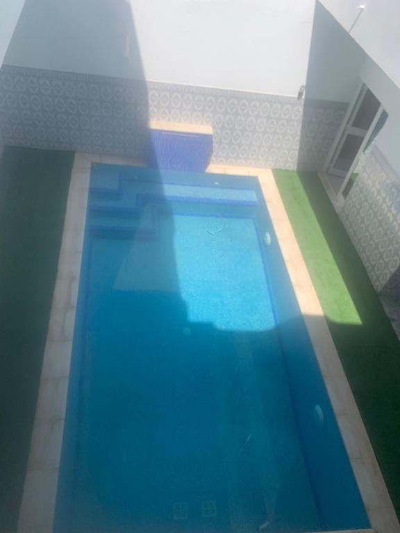 a person standing in front of a swimming pool at MAHDIA REJICHE MAISON AVEC PISCINE privee in Rejiche
