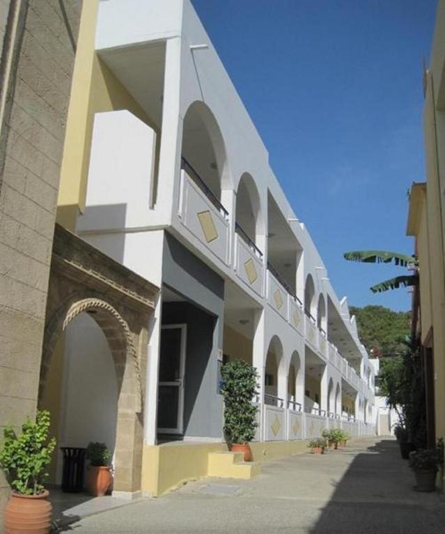 a white building with arches on the side of it at Stegna Star Apartments in Archangelos
