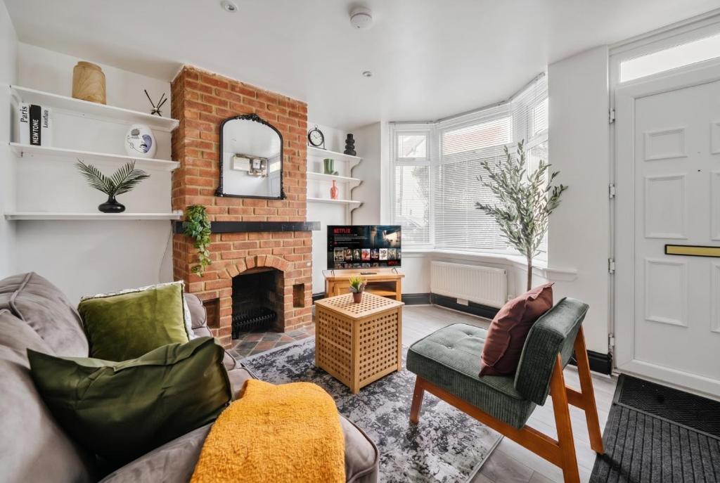 a living room with a couch and a fireplace at Modern Bletchley home with stylish decor in Bletchley