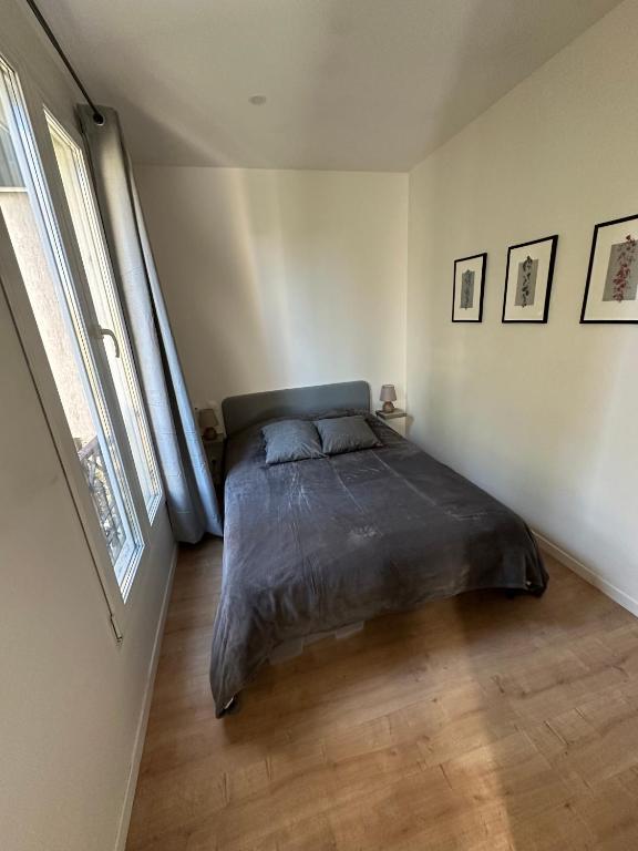 a bedroom with a bed in the corner of a room at La lumière d'Issy in Vanves