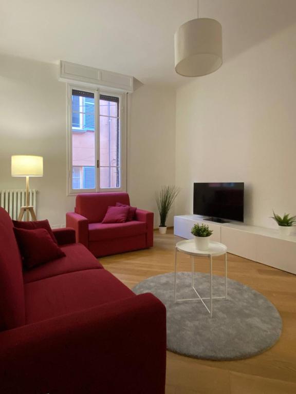 a living room with two red couches and a tv at Porta Nova, Bologna by Short Holidays in Bologna