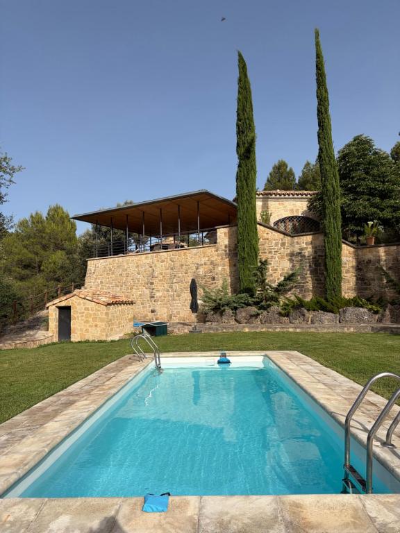 a swimming pool in a yard with a building at Villa Natalia in Monroyo