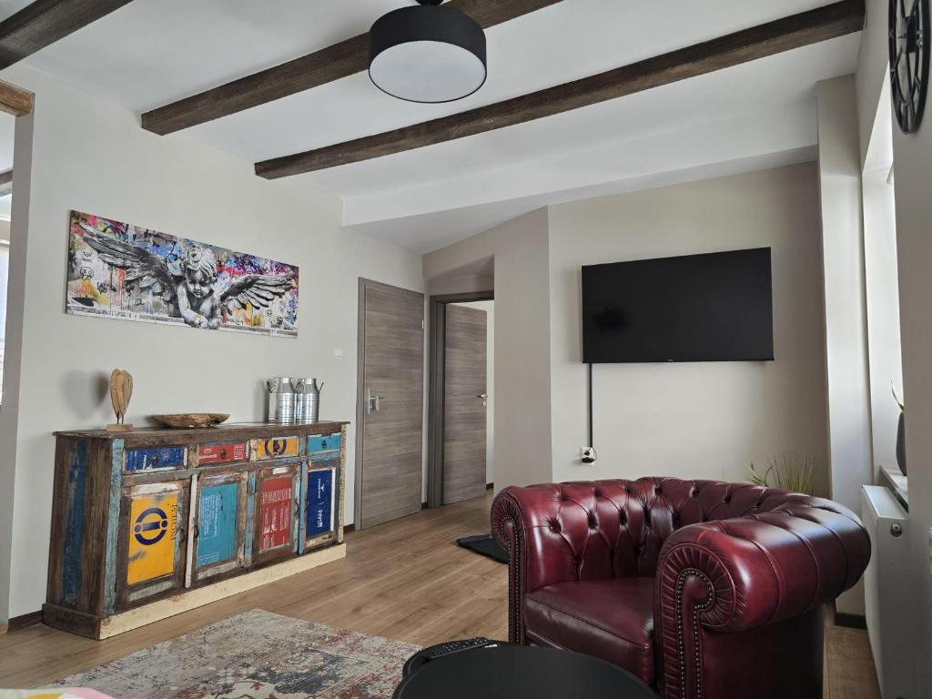 a living room with a leather chair and a television at Excellent house in Ediger-Eller