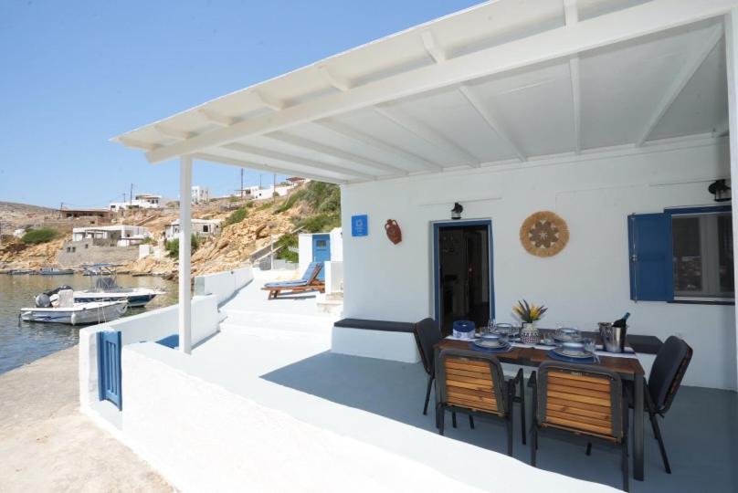 a patio with a table and chairs on a house at Onar Sifnos by the sea in Cherronisos