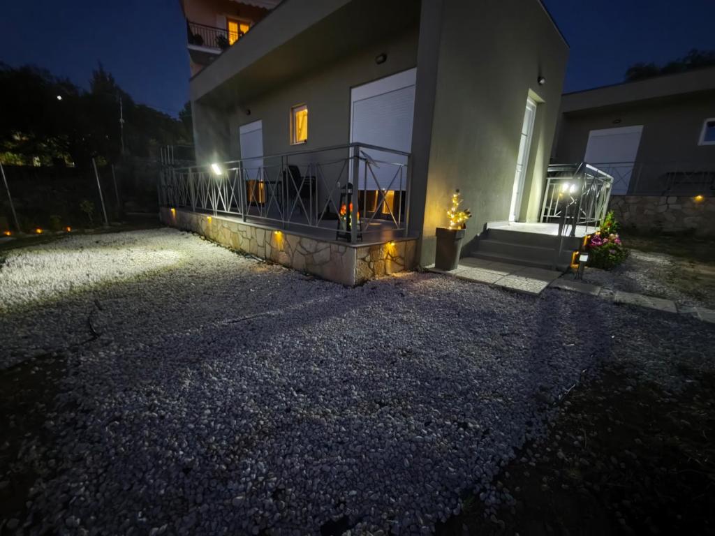 a house with a balcony at night with lights at Μπαλκόνι με Θέα in Pérdika