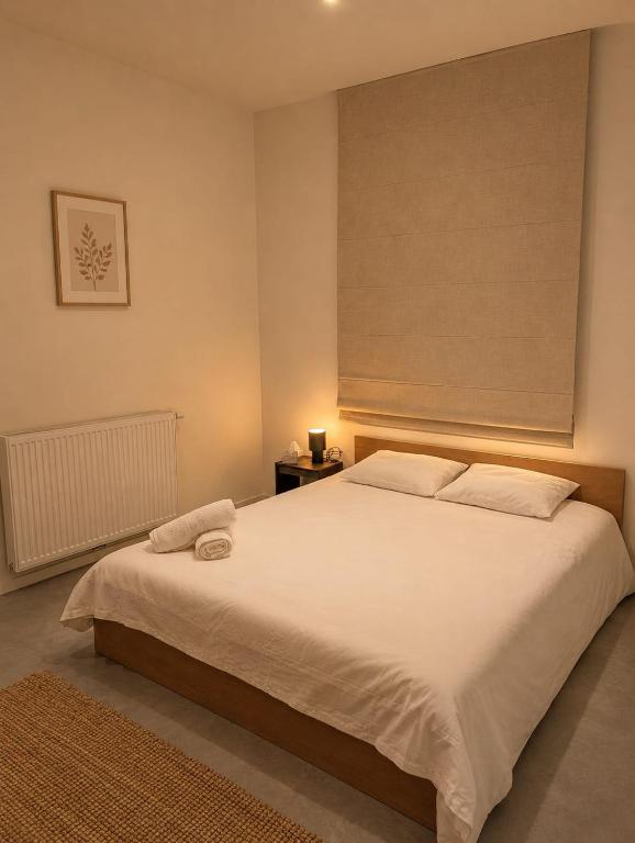 a bedroom with a large white bed with a window at Maison Bruxelles in Brussels