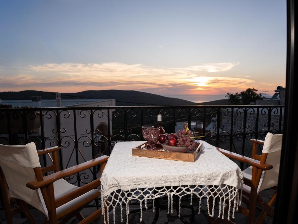 a table with a bowl of fruit on a balcony at Elata Stone Retreat Traditional Village House in Chios