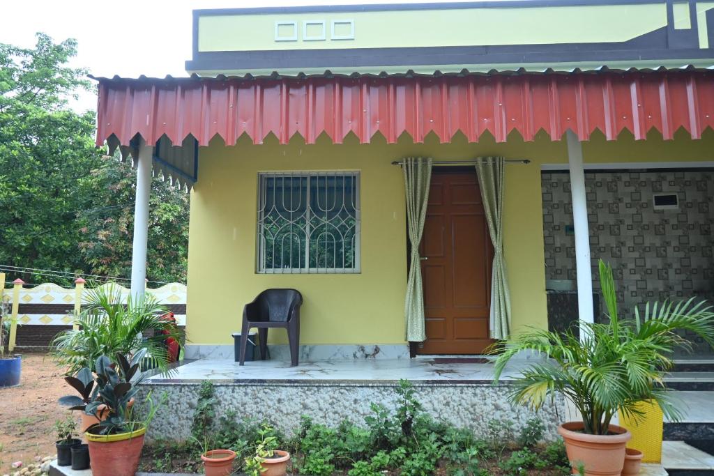 a yellow house with a black chair in front of it at Bagan Bilas Homestay in Jhilimili