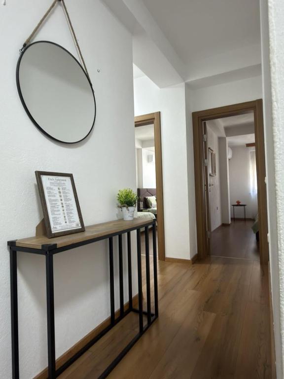 a mirror on a wall above a console table in a hallway at Eva apartment in Ohrid