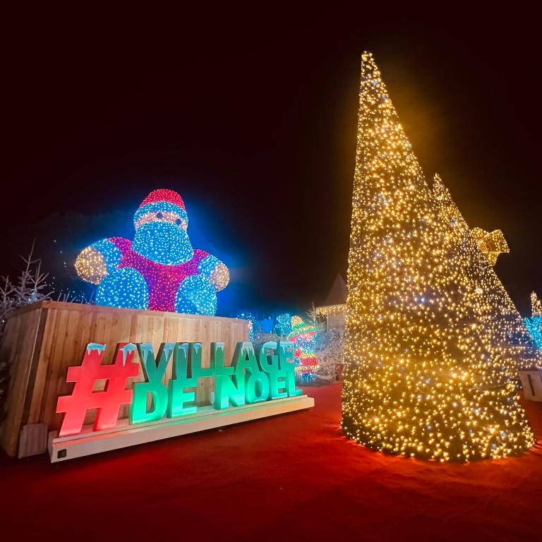 a christmas display with a christmas tree and a sign at Rivage hyper centre et plage a pied in Le Barcarès