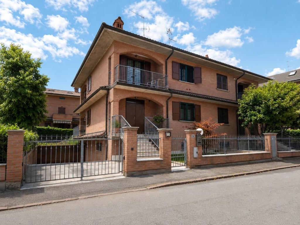 an old brick house with a wrought iron fence at Villa Porpora Luxury Design in Modena