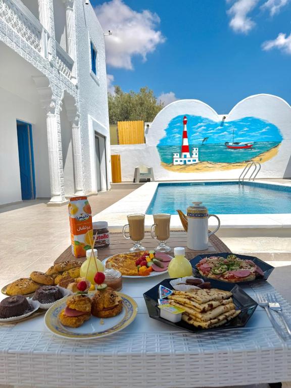 a table with food on it next to a pool at Djerba Moon in Djerba