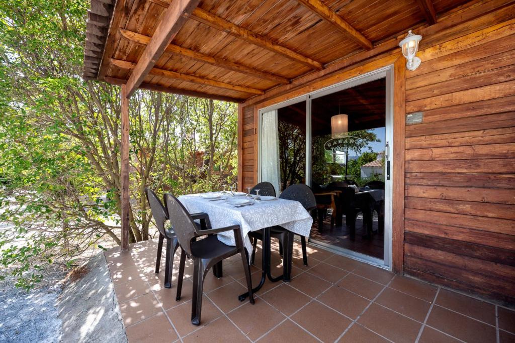 a dining table and chairs on a patio at Cabañas Cortijo el Helao in Pozo Alcón