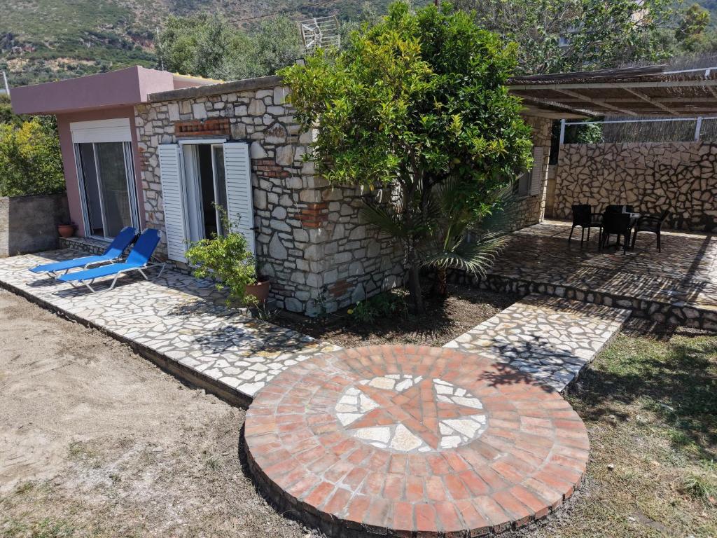a patio with a blue chair and a house at Blue Days Villa 2 in Shkalle Stenojt