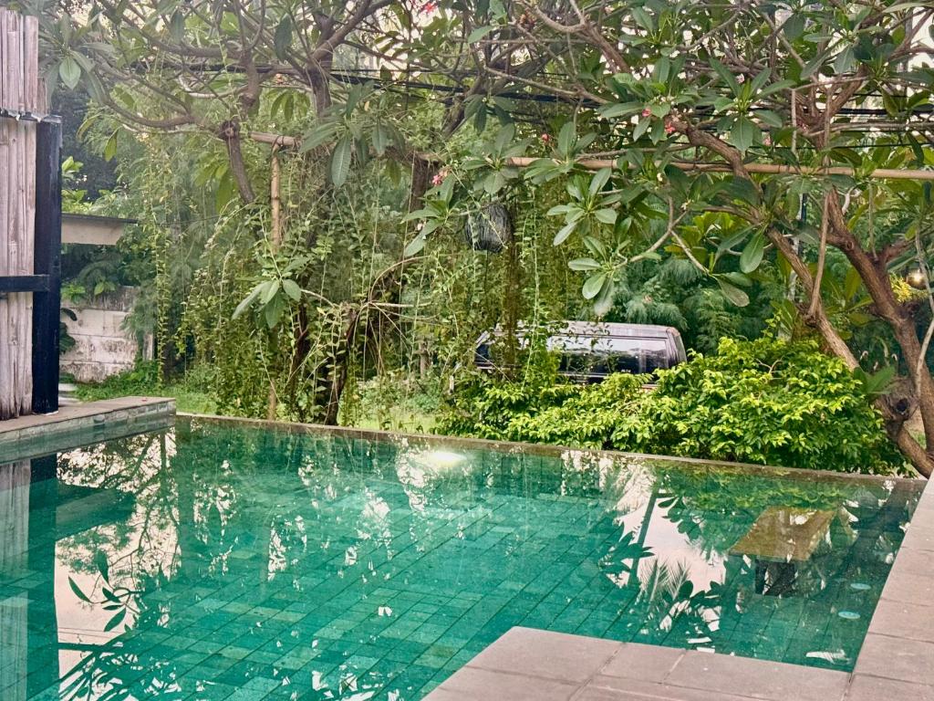 a swimming pool in the middle of a garden at Lombok House Mentigi in Teluknarat