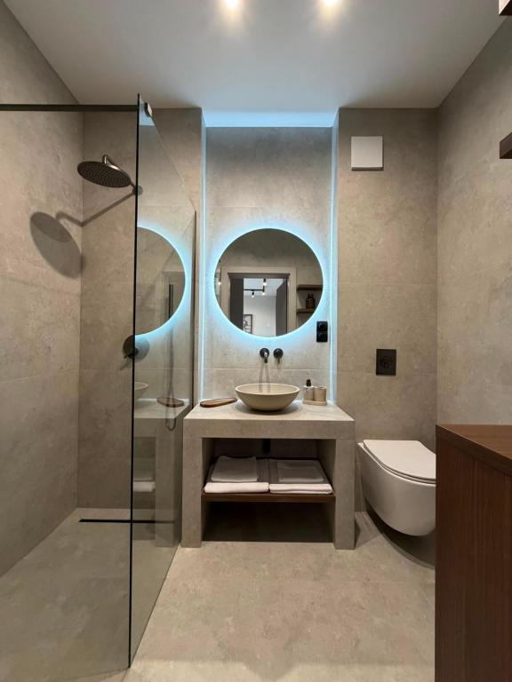 a bathroom with a sink and a toilet and a mirror at MJ Apartments in Łomża