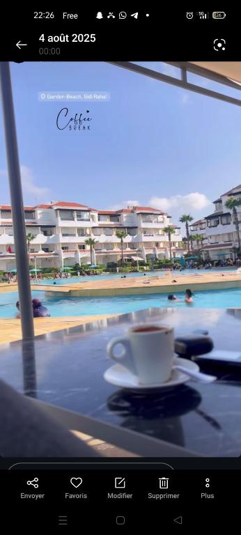 a cup of coffee sitting on a table with a view of a beach at Garden Beach 2 in Casablanca