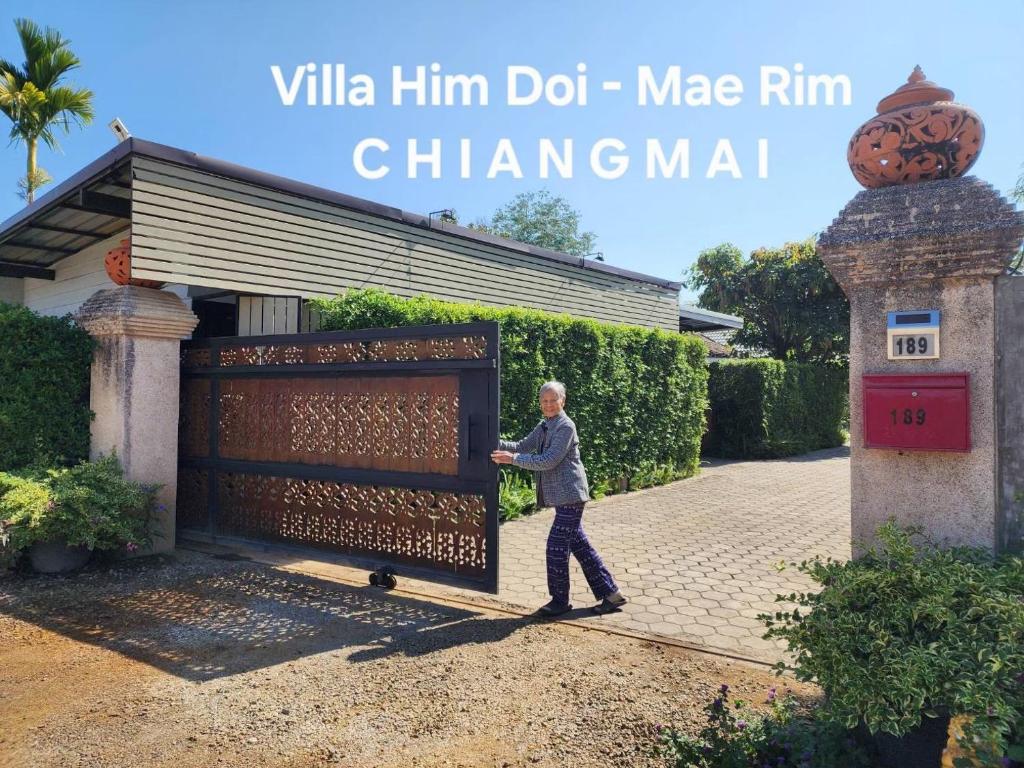 a man standing in front of a large metal gate at Villa Him Doi in Ban Mae Rim Nua