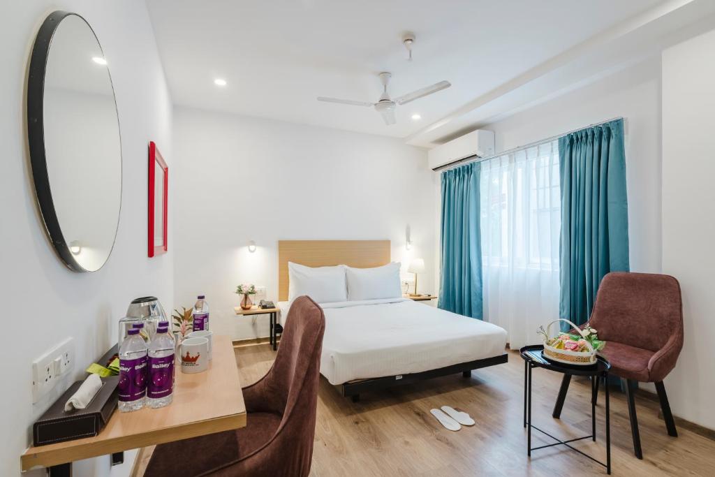 a hotel room with a bed and a desk and chairs at RCC Hotels Elite Begumpet in Hyderabad