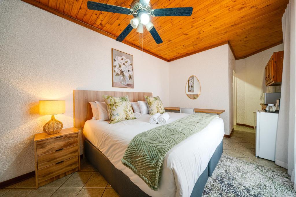 a bedroom with a bed and a ceiling fan at 3 Italeni in Secunda