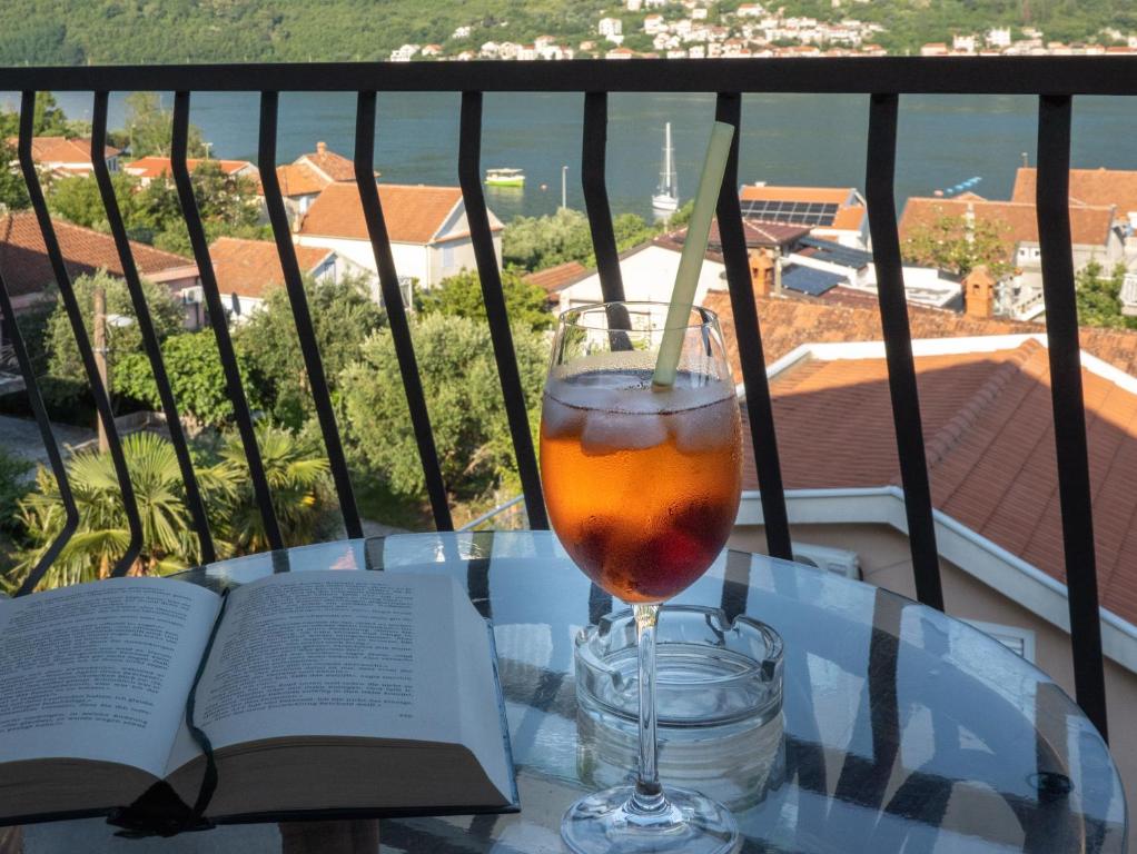 a glass of wine sitting on a table with a book at Seaside Village in Kamenari