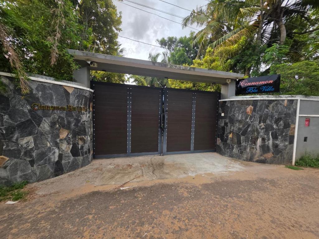 a garage door with a stone wall at Cinnamon Blu Villa in Panadura