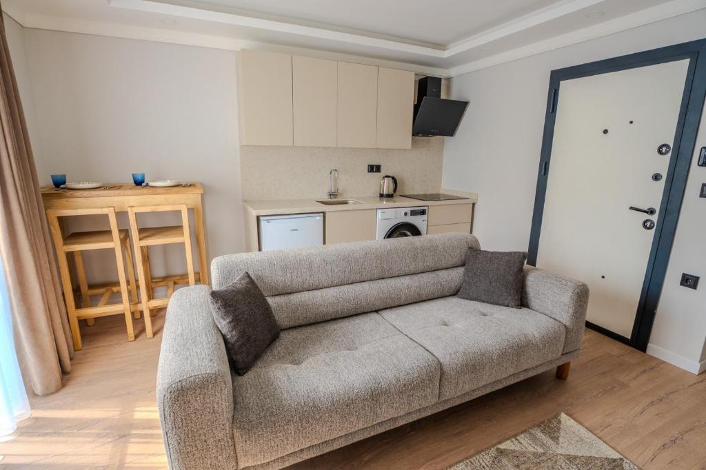 a living room with a couch and a kitchen at Royal Batın Apart Otel in Trabzon