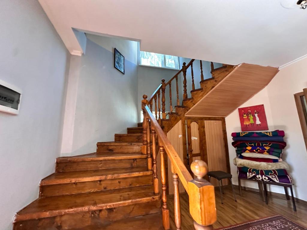 a wooden staircase in a home with a chair at Гостевой дом Достук in Bosteri