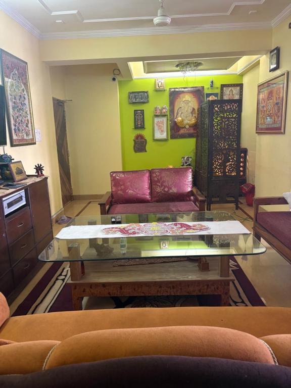 a living room with a couch and a glass table at Nilayam guest house in Patna