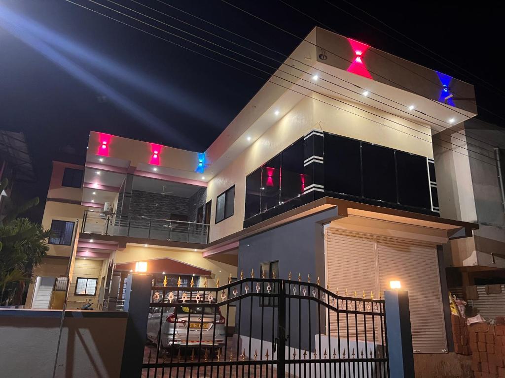 a large white house with lights on it at night at Beach Residency in Kāsarkod