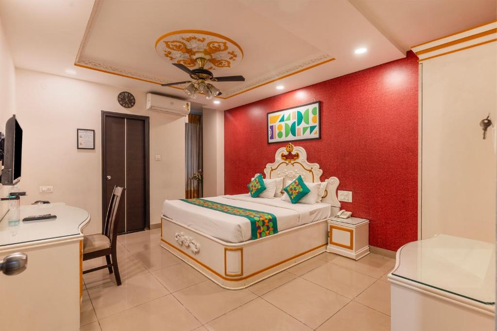 a bedroom with a king sized bed and a bathroom at Treebo Premium Raj Elegance Manyata Tech Park in Bangalore