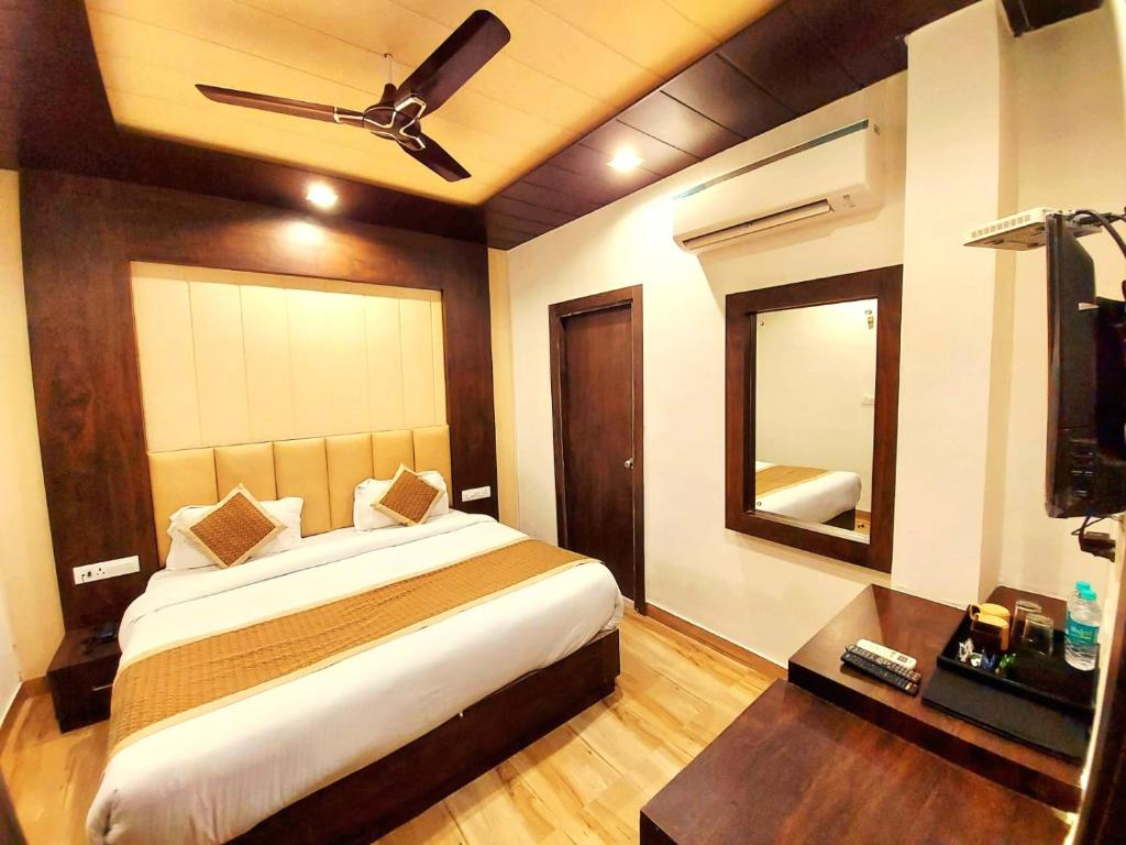 a bedroom with a large bed and a mirror at DL Hotels & Resorts Corbett in Dhikuli