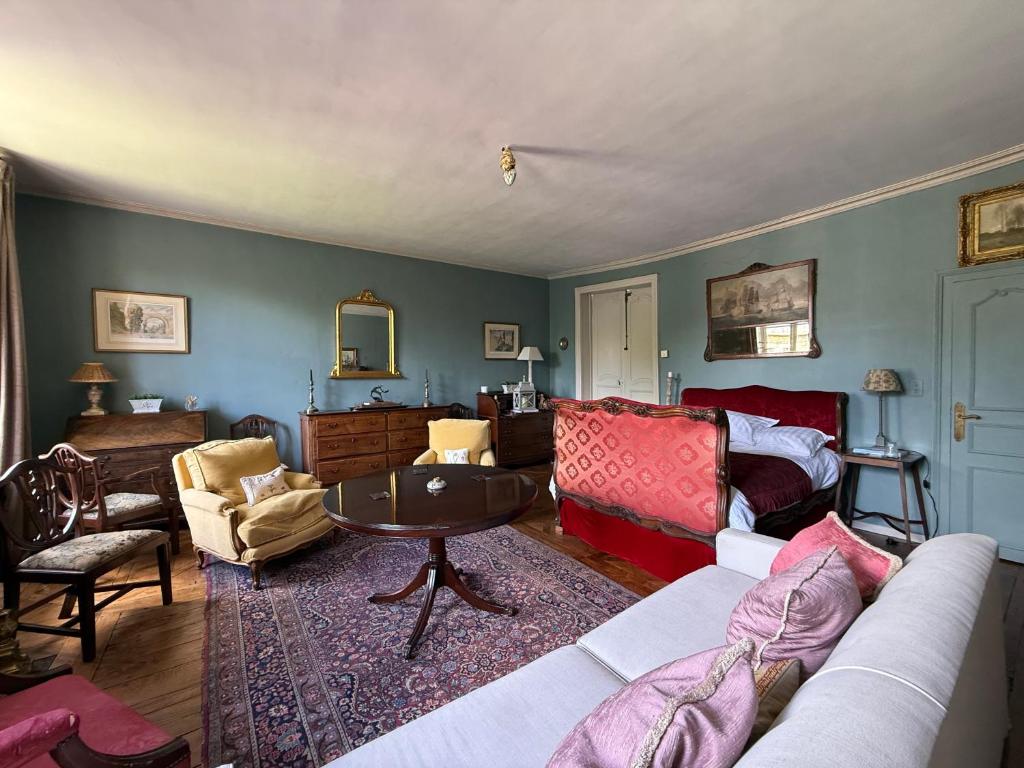 a living room with a couch and a table at L Epernon in Alençon