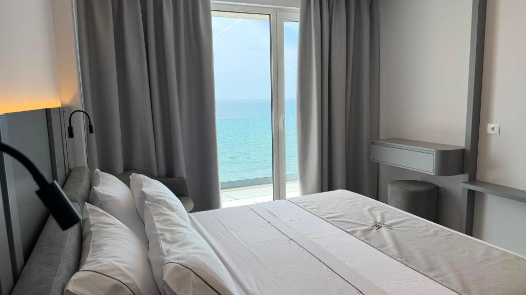 a bedroom with a bed with a view of the ocean at White Amfora Hotel in Shëngjin