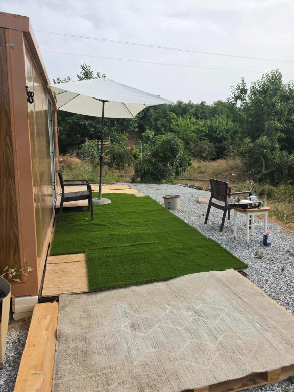 a patio with an umbrella and a bench and grass at Mar y campo in Algarrobo-Costa