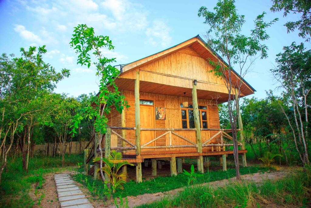 a wooden house in the middle of a forest at FRAPG camp and lodge in Mikumi