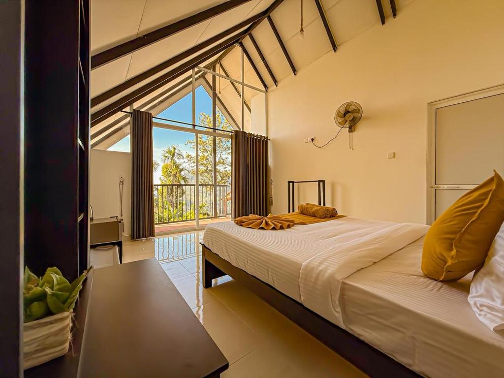 a bedroom with a large bed and a large window at Tera Ella Boutique Hotel by SANS in Ella