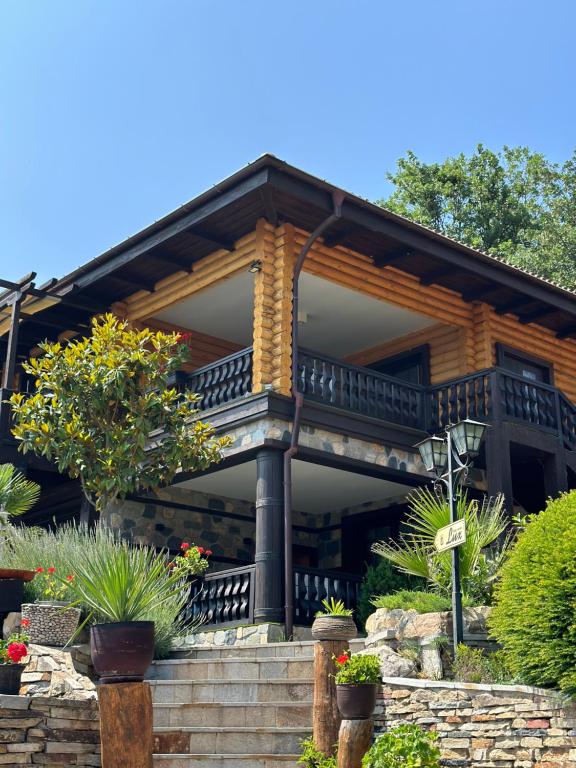 a house with a balcony and some plants at Deluxe House Glavatarski Han in Glavatartsi