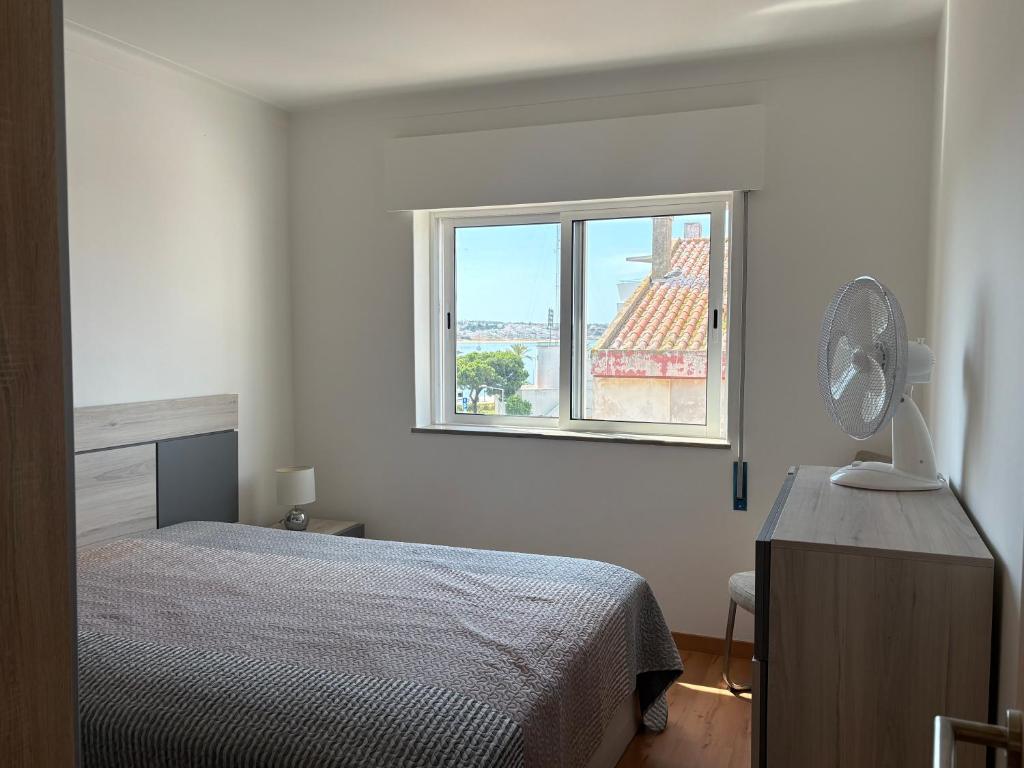 a white bedroom with a bed and a window at The Arade Riverview in Portimão