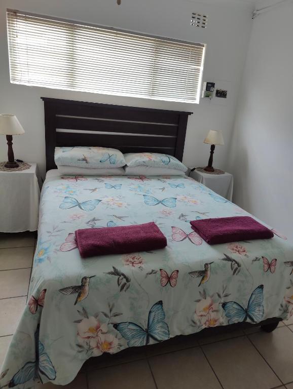 a bedroom with a bed with butterflies on it at Hunters Self Catering Apartment in East London