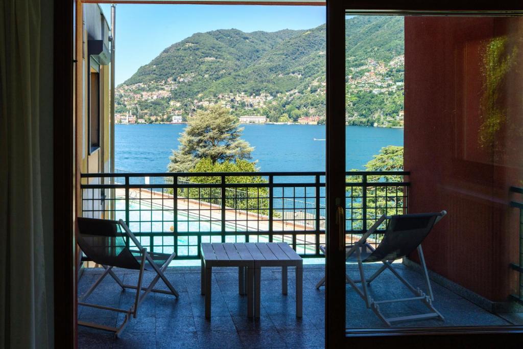 a balcony with a table and chairs and a view of the water at Il Sogno di Angelo - Blevio in Blevio