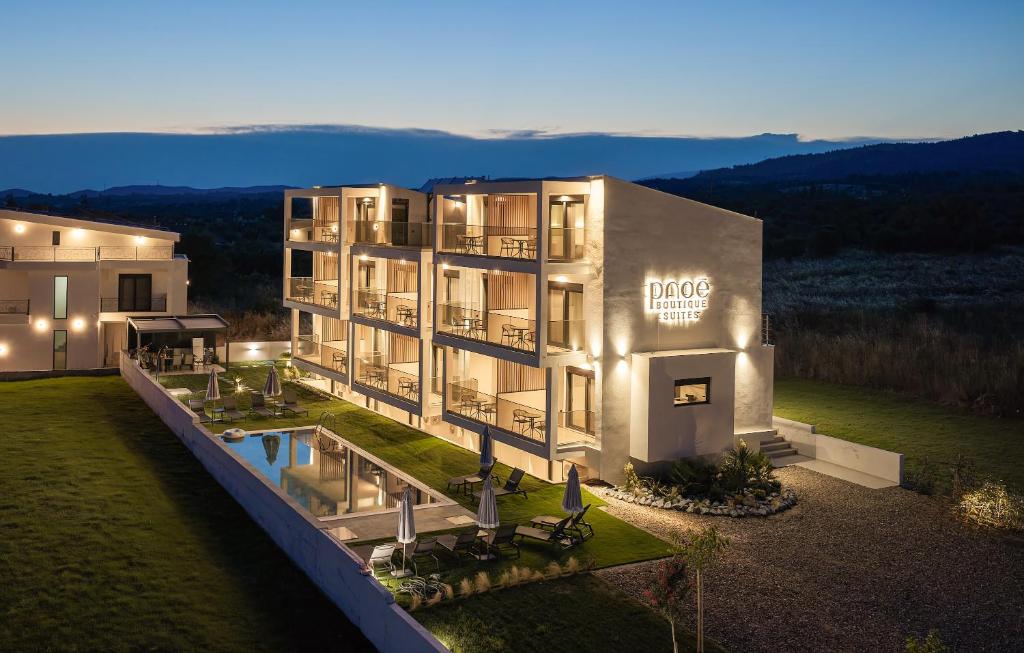 a large building with a pool in front of it at Pnoe Boutique suites in Nikiti