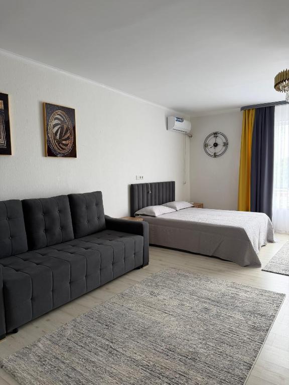 a living room with a bed and a couch at Raduga West in Koshkolʼ