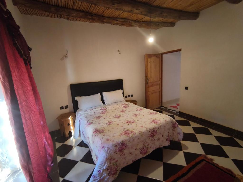 a bedroom with a bed and a checkered floor at Riad tinghir in Tinerhir
