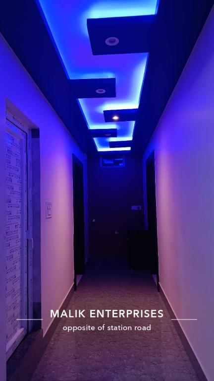a dark room with blue lights on the ceiling at Hotel Malik Palace in Noāmundi
