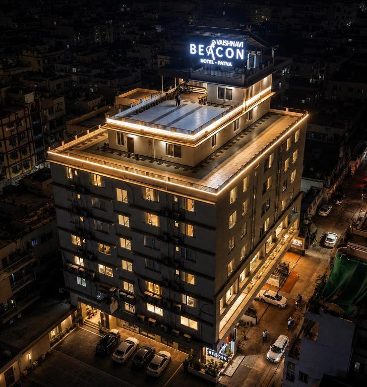 a building with a sign on top of it at night at Vaishnavi Beacon Hotel Patna in Patna