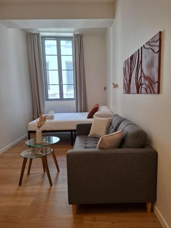 a living room with a couch and a table at Studio de charme - Centre Vienne - Proche gare in Vienne