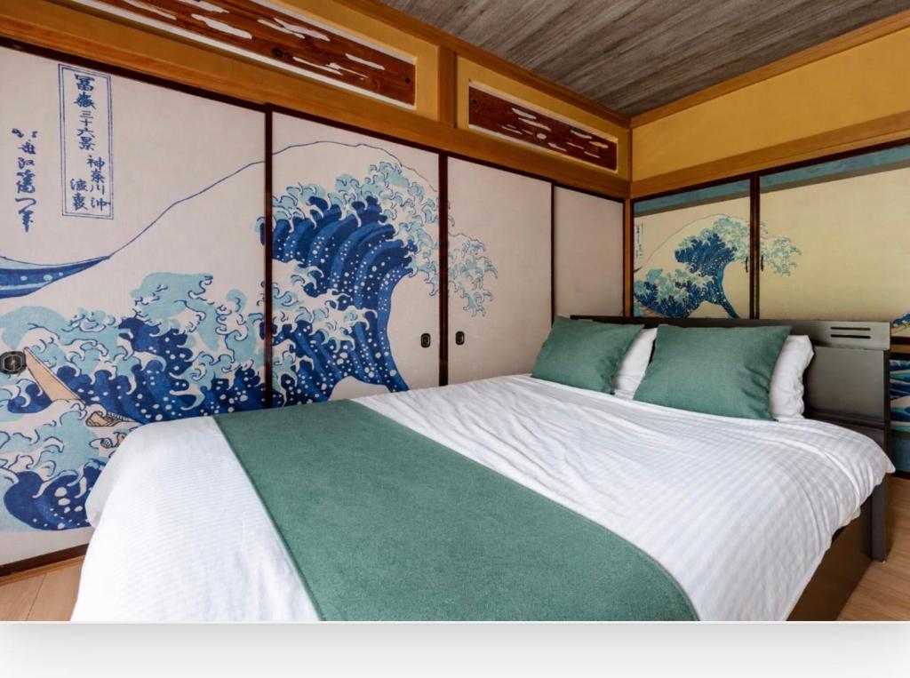 a bedroom with a bed with a painting on the wall at OZ nikko in Nikko