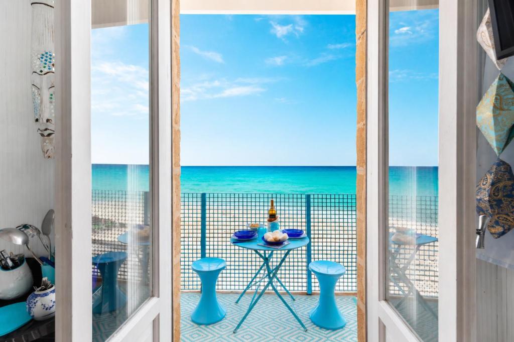 a room with a view of the ocean from a balcony at Casa Nettuno in Ostuni