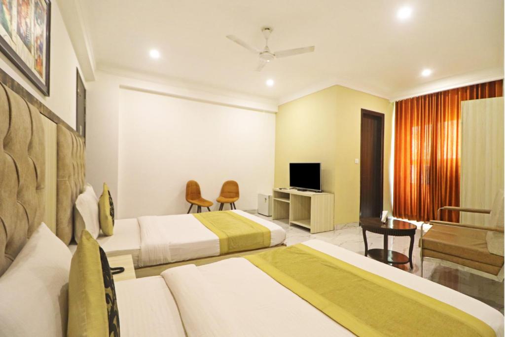 a hotel room with two beds and a television at Hotel Almora Suites - Near Delhi Airport in New Delhi